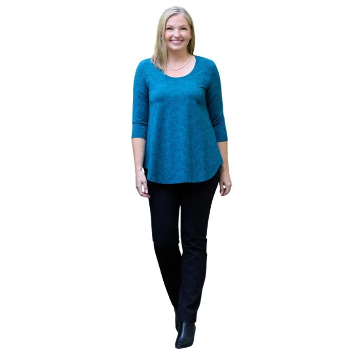 a women wearing teal empire print jazz  top and black nadia pants front view on white background