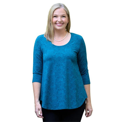a women wearing teal empire print jazz  top waist up front view on white background