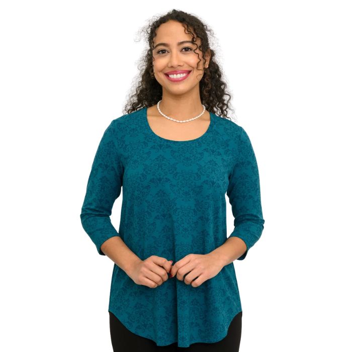 a women wearing teal empire print jazz  top waist up front view on white background