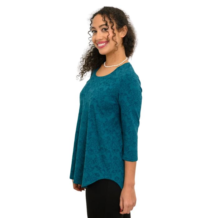 a women wearing teal empire print jazz  top waist up side view on white background