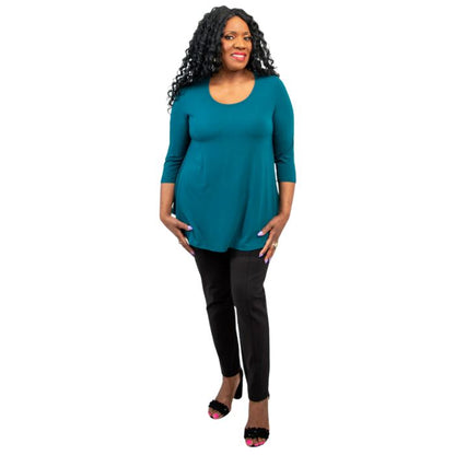 female model wearing jazz teal green three quarter sleeve top and nadia black pants front view on white background