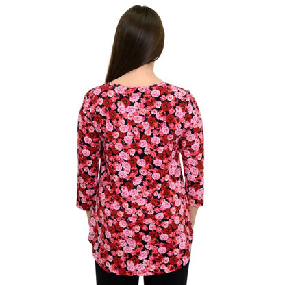 a woman wearing vermillion rose print jazz top waist up back view on white background