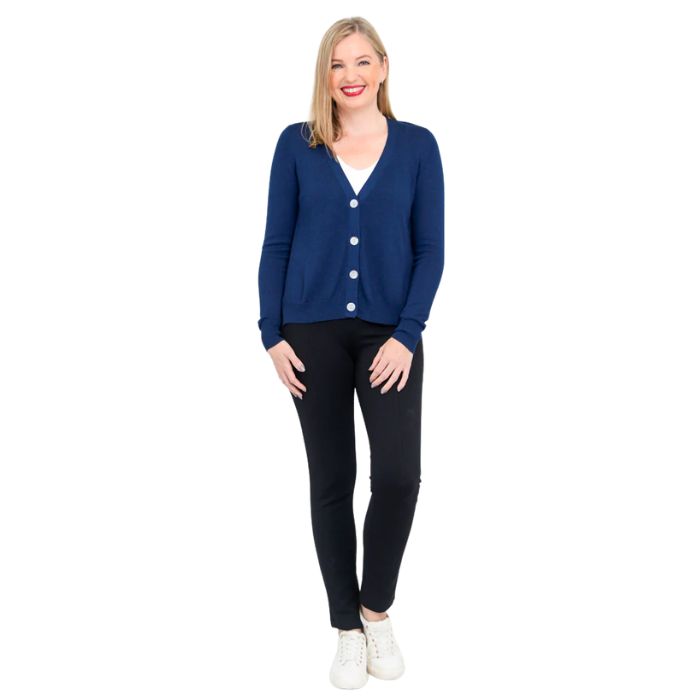female model wearing indigo blue jessica button up cardigan sweater, white reanna tank top and black nadia pants front view on white background