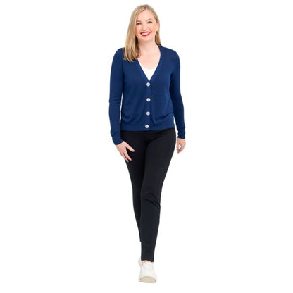 female model wearing indigo blue jessica button up cardigan sweater, white reanna tank top and black nadia pants front view on white background