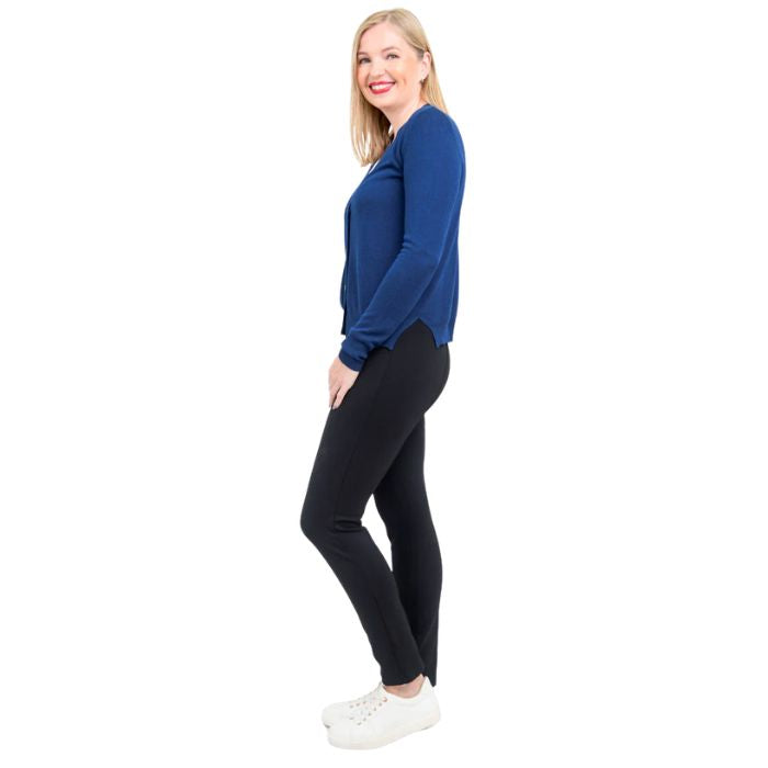 female model wearing indigo blue jessica button up cardigan sweater, white reanna tank top and black nadia pants side view on white background