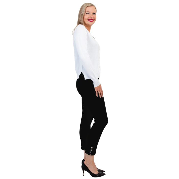 female model wearing white jessica button up cardigan sweater, black reanna tank top and black nadine cropped pants side view on white background