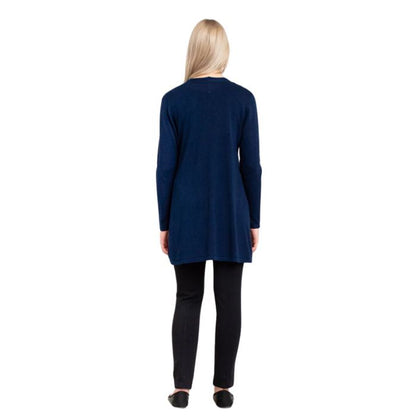 female model wearing indigo blue justine draped cardigan sweater and nlack nadia pants back view on white background