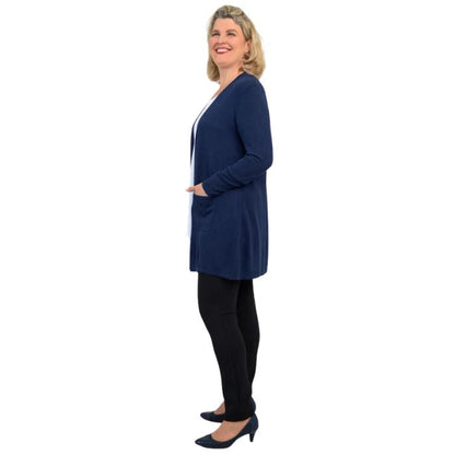 female model wearing indigo blue justine draped cardigan sweater, white jazz tank top and nlack nadia pants side  view on white background