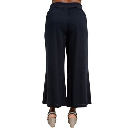 female model wearing black landon capri pants back view on white background