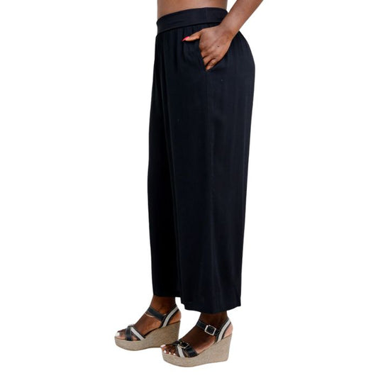 female model wearing black landon capri pants side view on white background