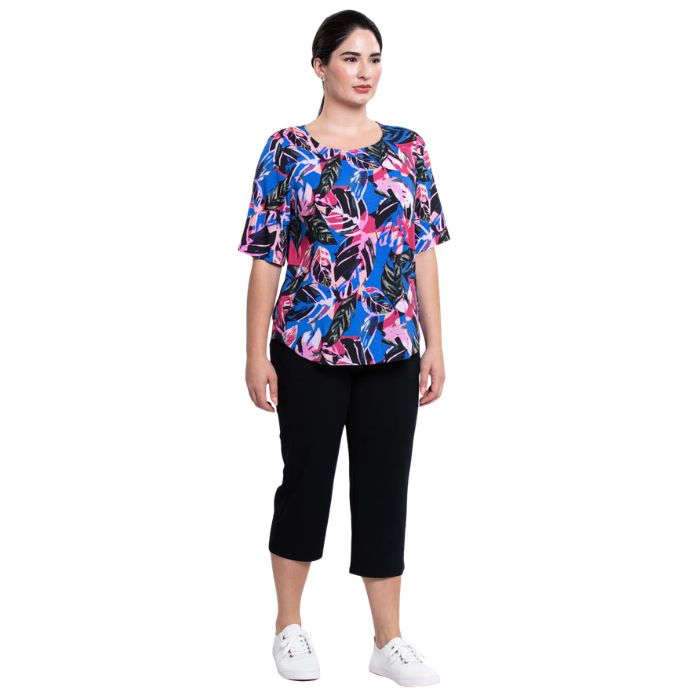 female model wearing pink bonita print liza top and black nadine cropped pants front view on white background