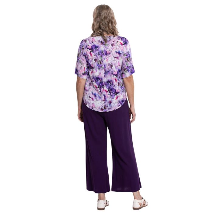 model wearing royale dynasty liza top and royale purple landon capri pants back view on white background