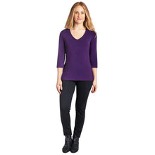 female model wearing mia royal purple three quarter sleeve top and nadia black pants front view on white background