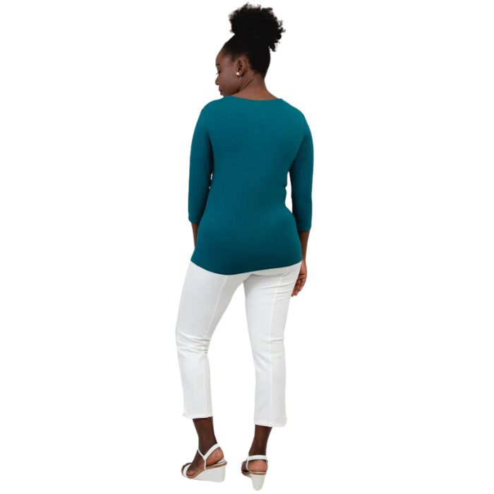 female model wearing mia teal green three quarter sleeve top and nadine white cropped pants back view on white background