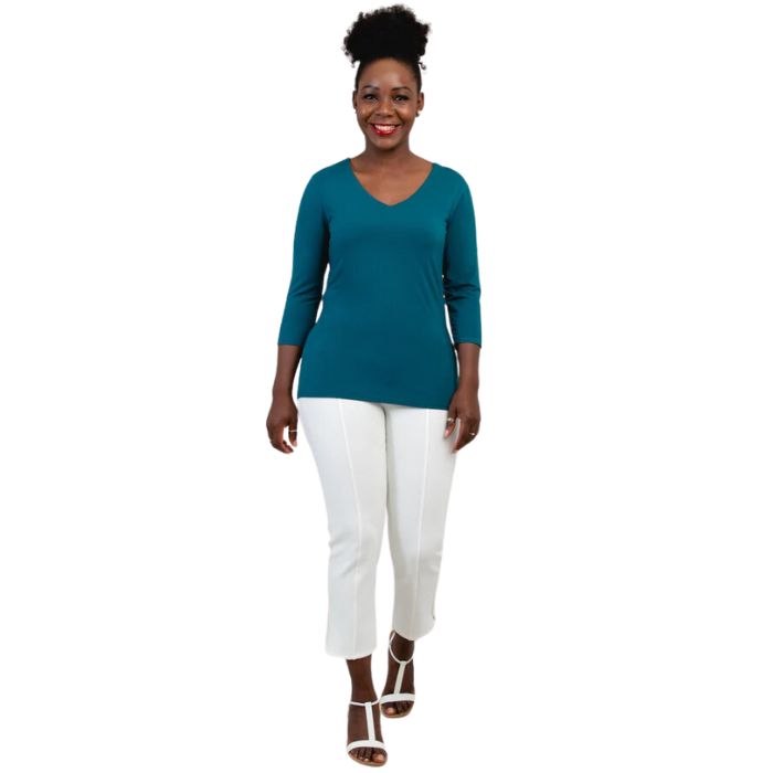 female model wearing mia teal green three quarter sleeve top and nadine white cropped pants front view on white background