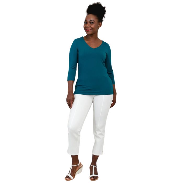 female model wearing mia teal green three quarter sleeve top and nadine white cropped pants front view on white background