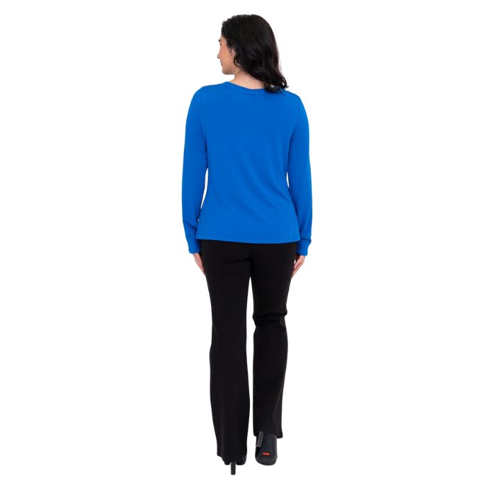 female model wearing mona cobalt blue long sleeve top and daya black pants back view on white background