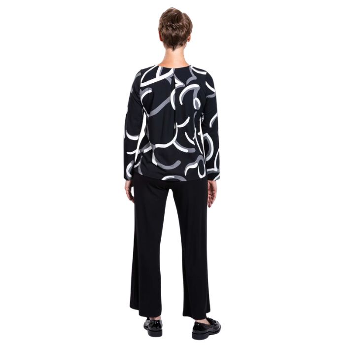 woman wearing black white focus print peggy top and black parker pants back view set on a white background