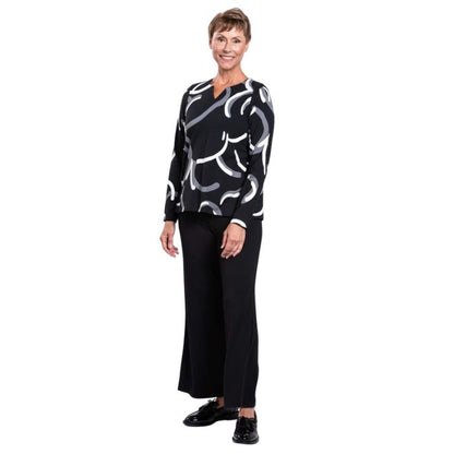 woman wearing black white focus print peggy top and black parker pants front view set on a white background