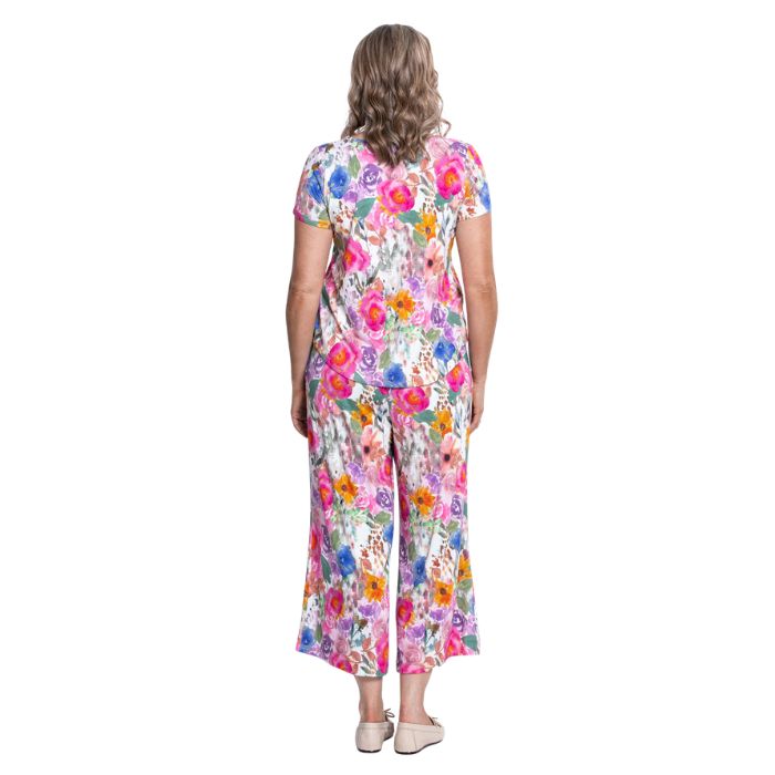 female model wearing pink bouquet print ritzy top and pink bouquet pants back view on white background