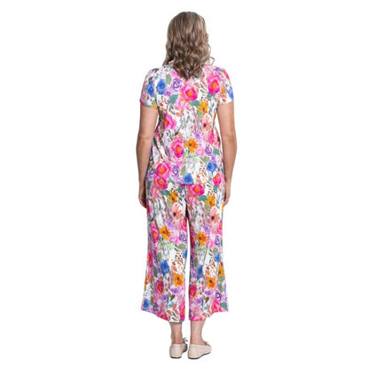 female model wearing pink bouquet print ritzy top and pink bouquet pants back view on white background