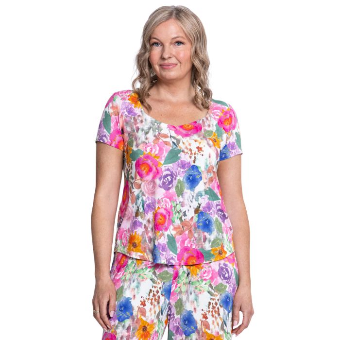 female model wearing pink bouquet print ritzy top front view on white background