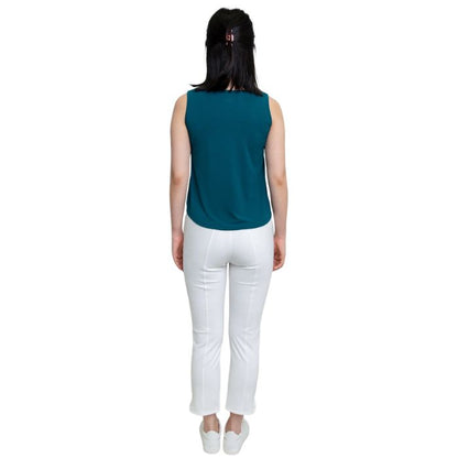 female model wearing teal green ritzy tank top and white nadine cropped pants back view on white background