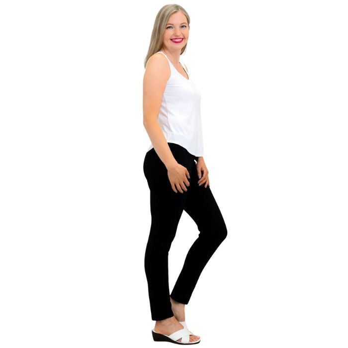female model wearing white ritzy tank top and black nadia pants side view on white background