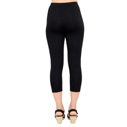 female model wearing black ruby capri leggings back view on white background