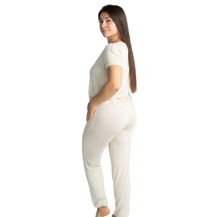 female model wearing sophie almond milk white short sleeve tee and banded ankle pant two piece pajama set back view on white background