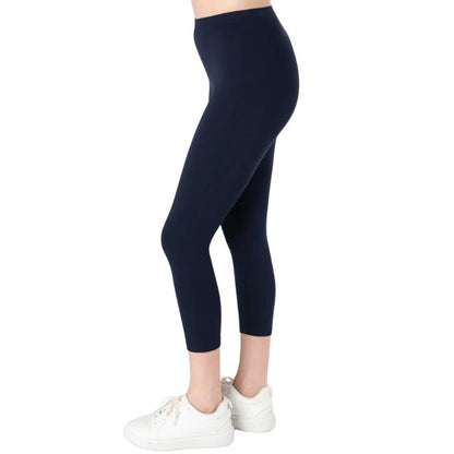 female model wearing ink blue suri capri length leggings side view on white background 