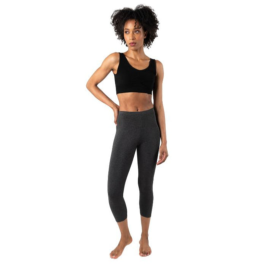 female model wearing charcoal grey suri capri length leggings and terrera essential bralette front view on white background 