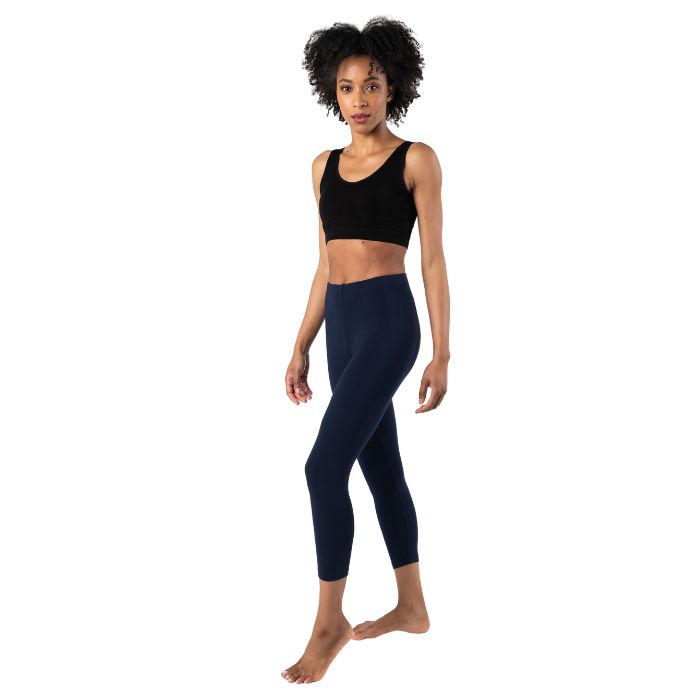 female model wearing ink blue suri capri length leggings and black terrera essential bralette front view on white background 