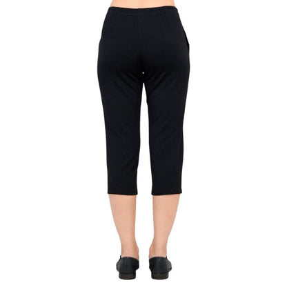 female model wearing black susan capri pants back view on white background