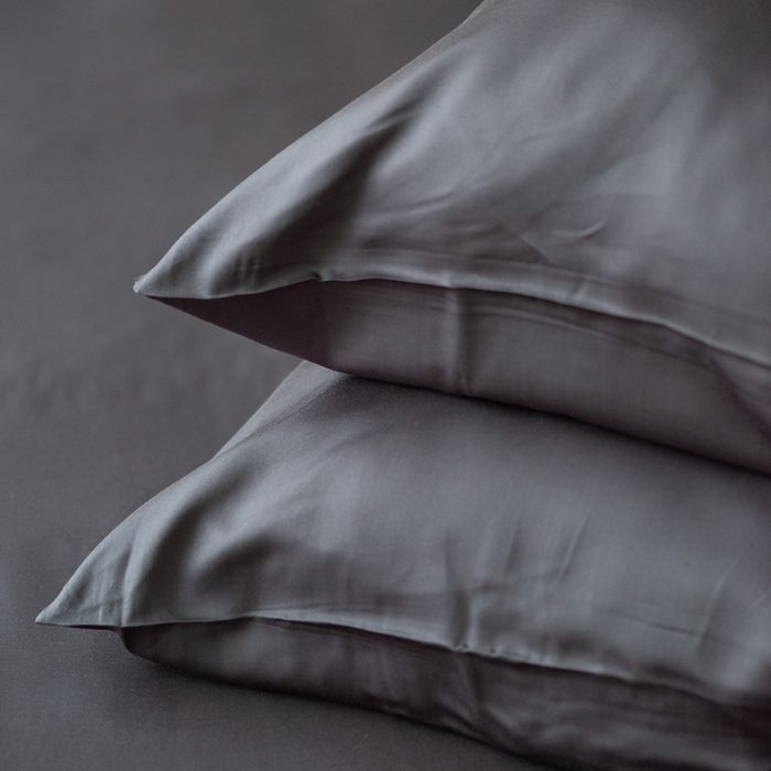 two charcoal grey terrera bamboo pillowcases on pillows stacked on grey background