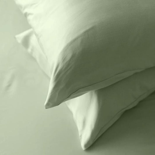 desert sage green terrera two bamboo pillowcases on pillows stacked on bed with desert sage green bed sheets