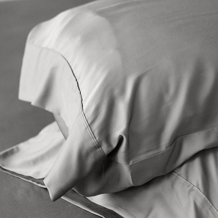 two grey terrera bamboo pillowcases on pillows stacked on grey background