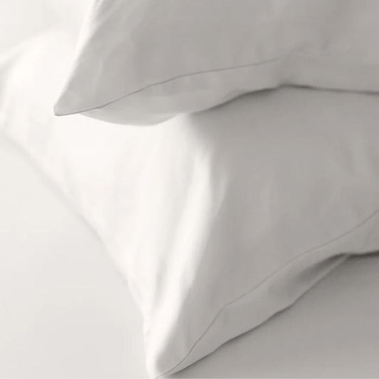 two pearl white terrera bamboo pillowcases on pillows stacked on pearl white sheet