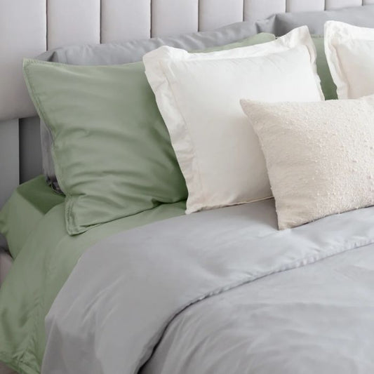 bed made with desert sage green bed sheets and pillowcasses and grey duvet cover and pillow cases