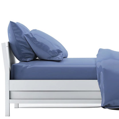 bed made with mineral blue sheet set, flat sheet, fitted sheet and two pillowcases on white background
