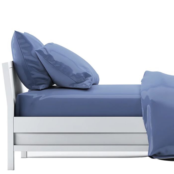 bed made with mineral blue sheet set, flat sheet, fitted sheet and two pillowcases on white background