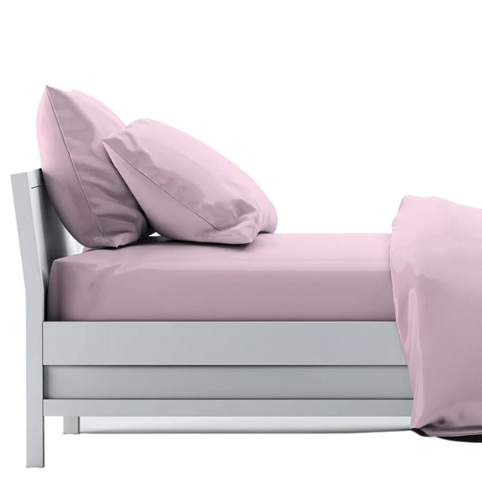 bed made with pale rose pink sheet set, flat sheet, fitted sheet and two pillowcases on white background