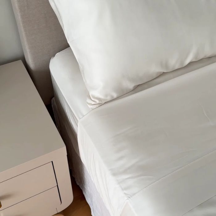 bed made with pearl white sheet set, flat sheet, fitted sheet and pillowcase