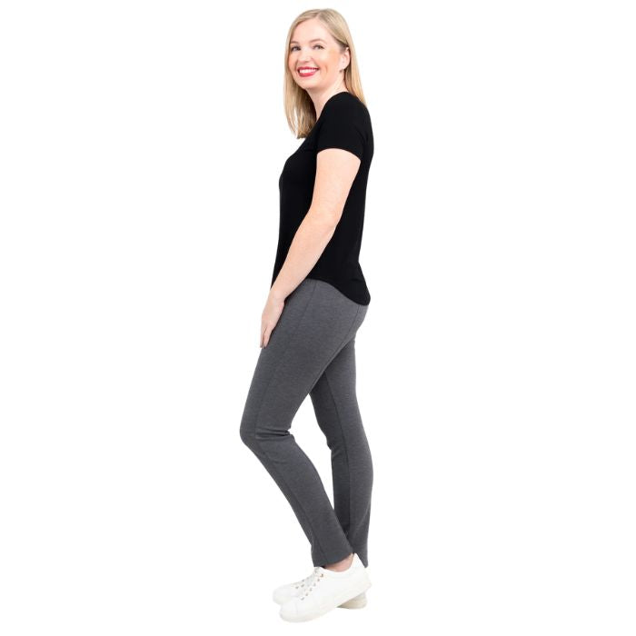 female model wearing black tessa tee and granite grey nadia pants side view on white background