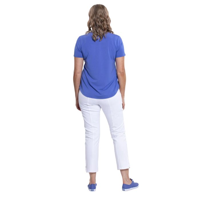 female model wearing periwinkle blue tessa tee and white nadine cropped pants back view on white background
