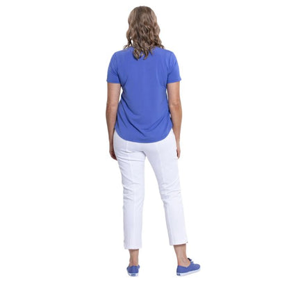 female model wearing periwinkle blue tessa tee and white nadine cropped pants back view on white background