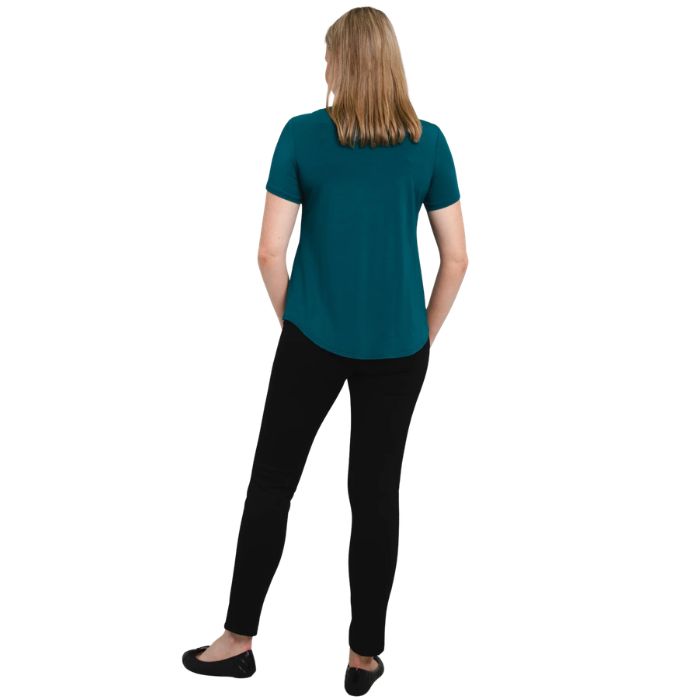female model wearing teal green tessa tee and black nadia pants back view on white background