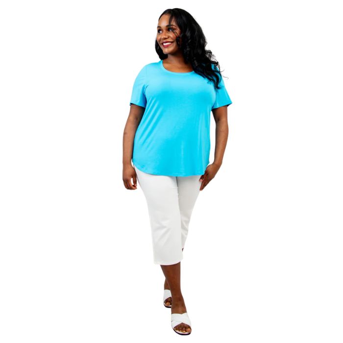 female model wearing turquoise blue tessa tee and white nadine cropped pants front view on white background