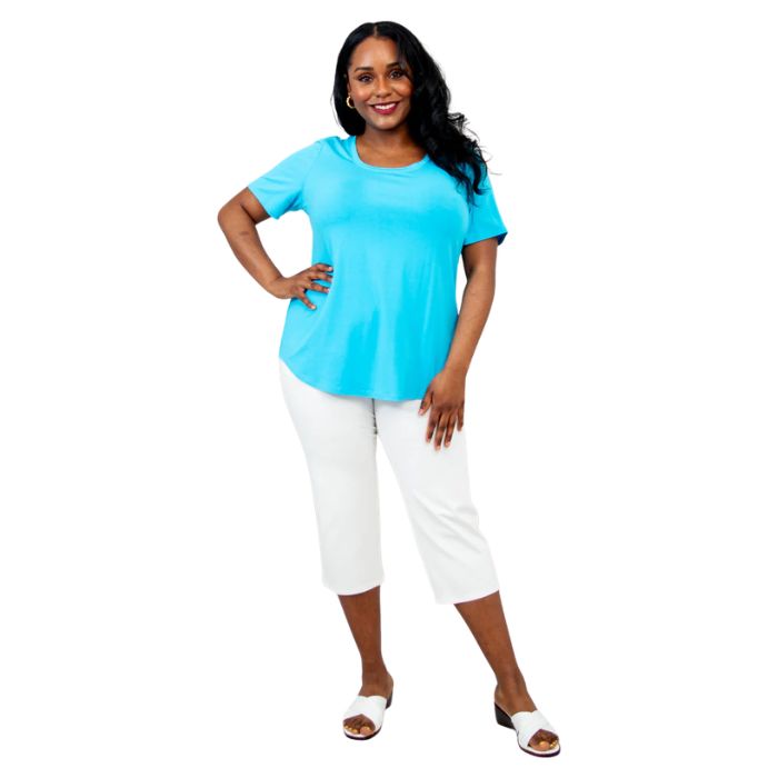 female model wearing turquoise blue tessa tee and white nadine cropped pants front view on white background