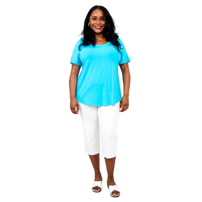 female model wearing turquoise blue tessa tee and white nadine cropped pants front view on white background